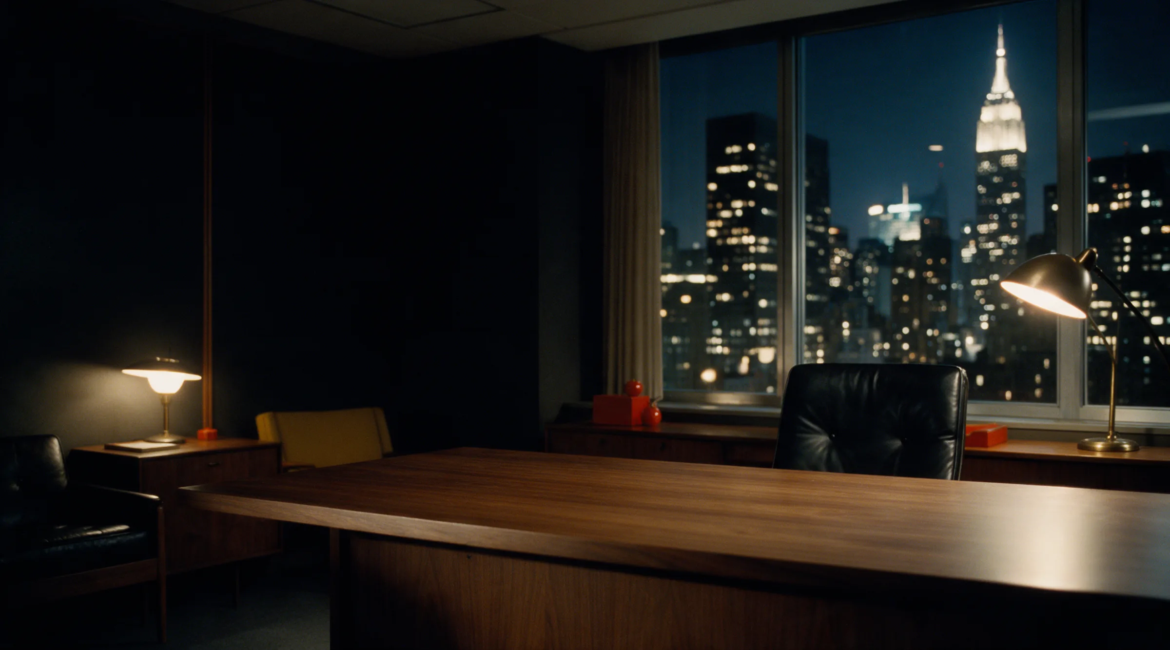 A dark 1960s corner office at night, the Manhattan skyline through the window, an empty walnut desk.